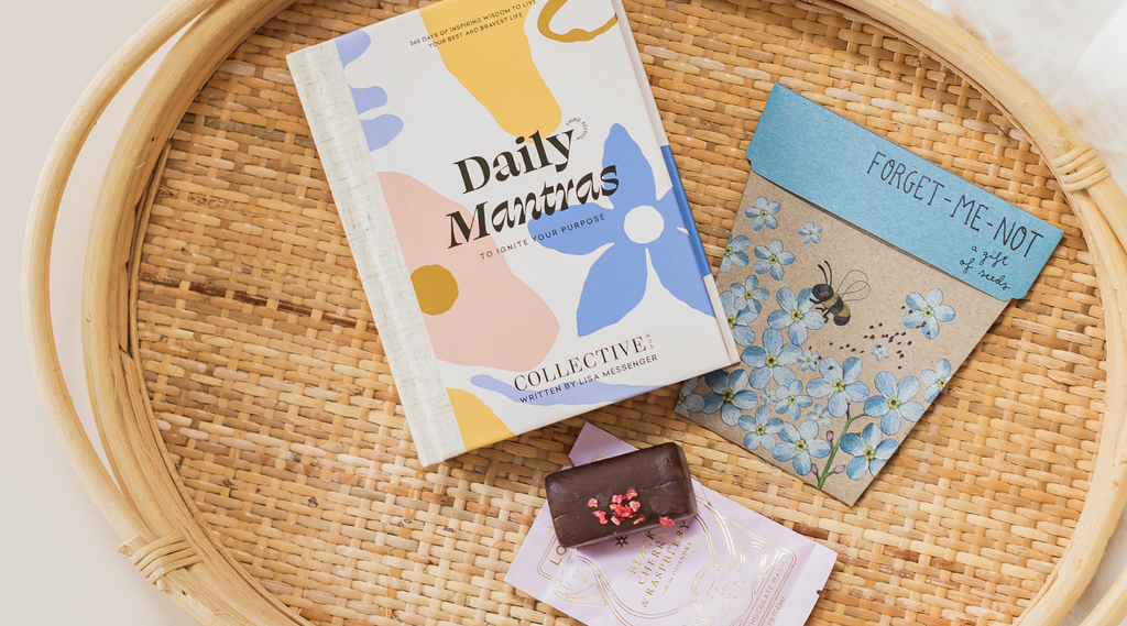 Products from a birthday gift box including, daily mantras book, flower seeds, and a artisan chocolate.