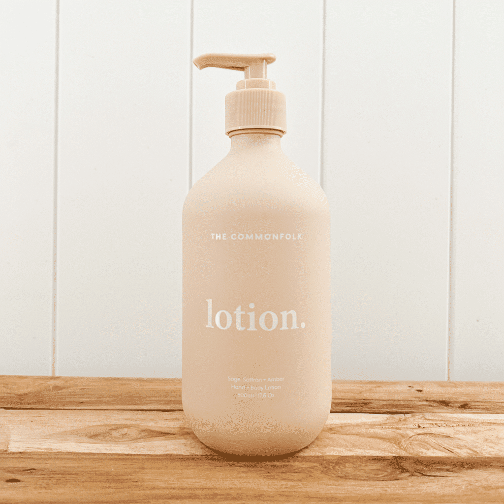 Bottle of The Commonfolk Collective hand and body lotion in a nude bottle.